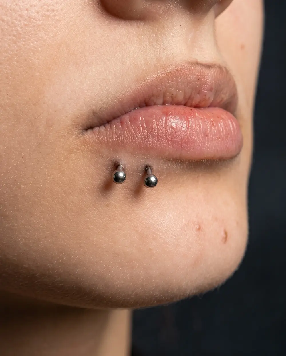 Dudak altında uygulanmış çift labret piercing yakın plan görünümü