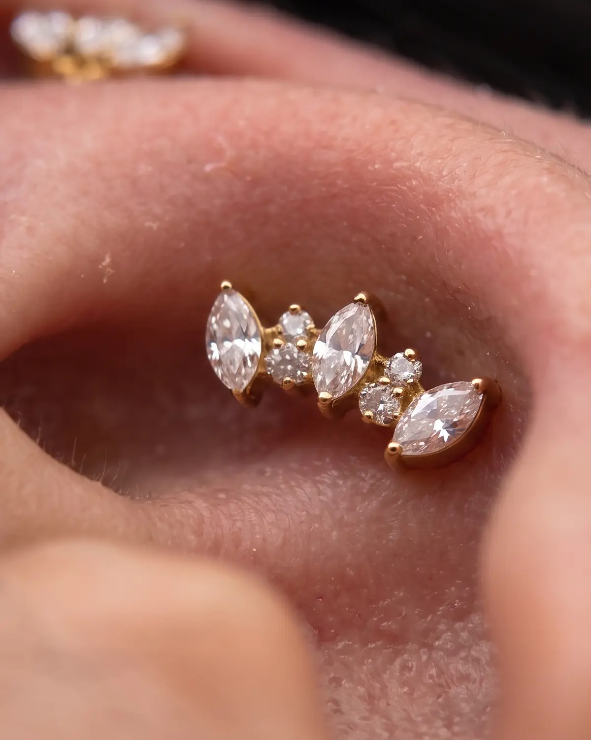 Ear curation kompozisyonundaki taşlı altın tonlu takı detayı