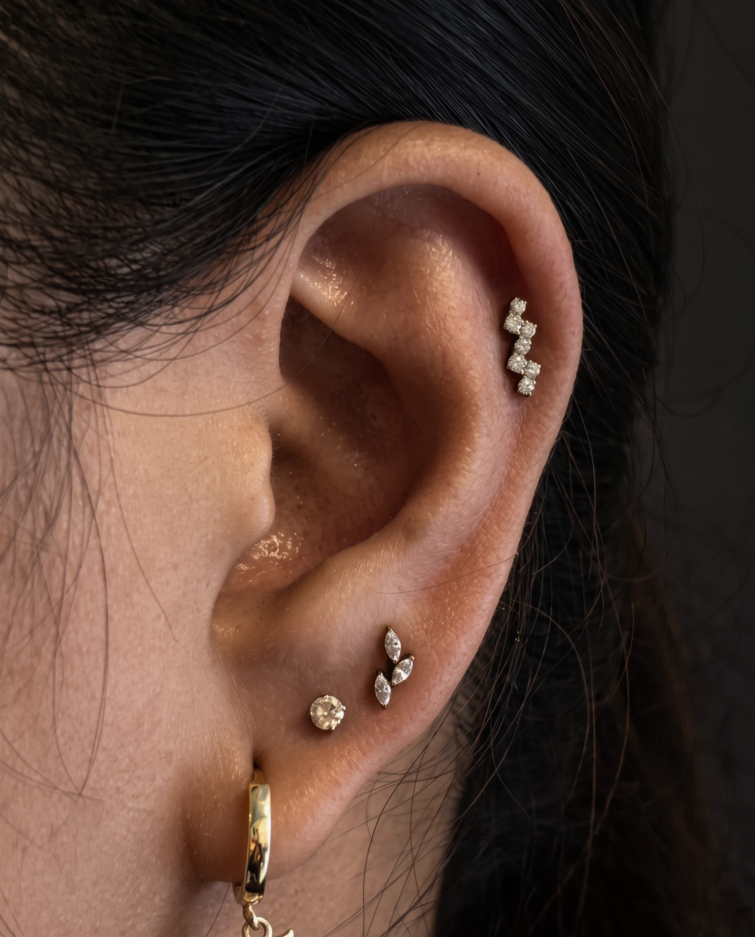 Taşlı piercing takılarıyla kulak kombinasyonu